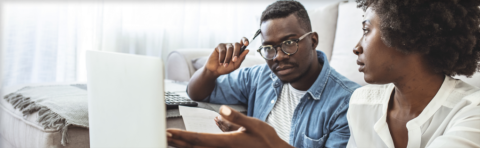 Couple looking at computer screen while paying bills